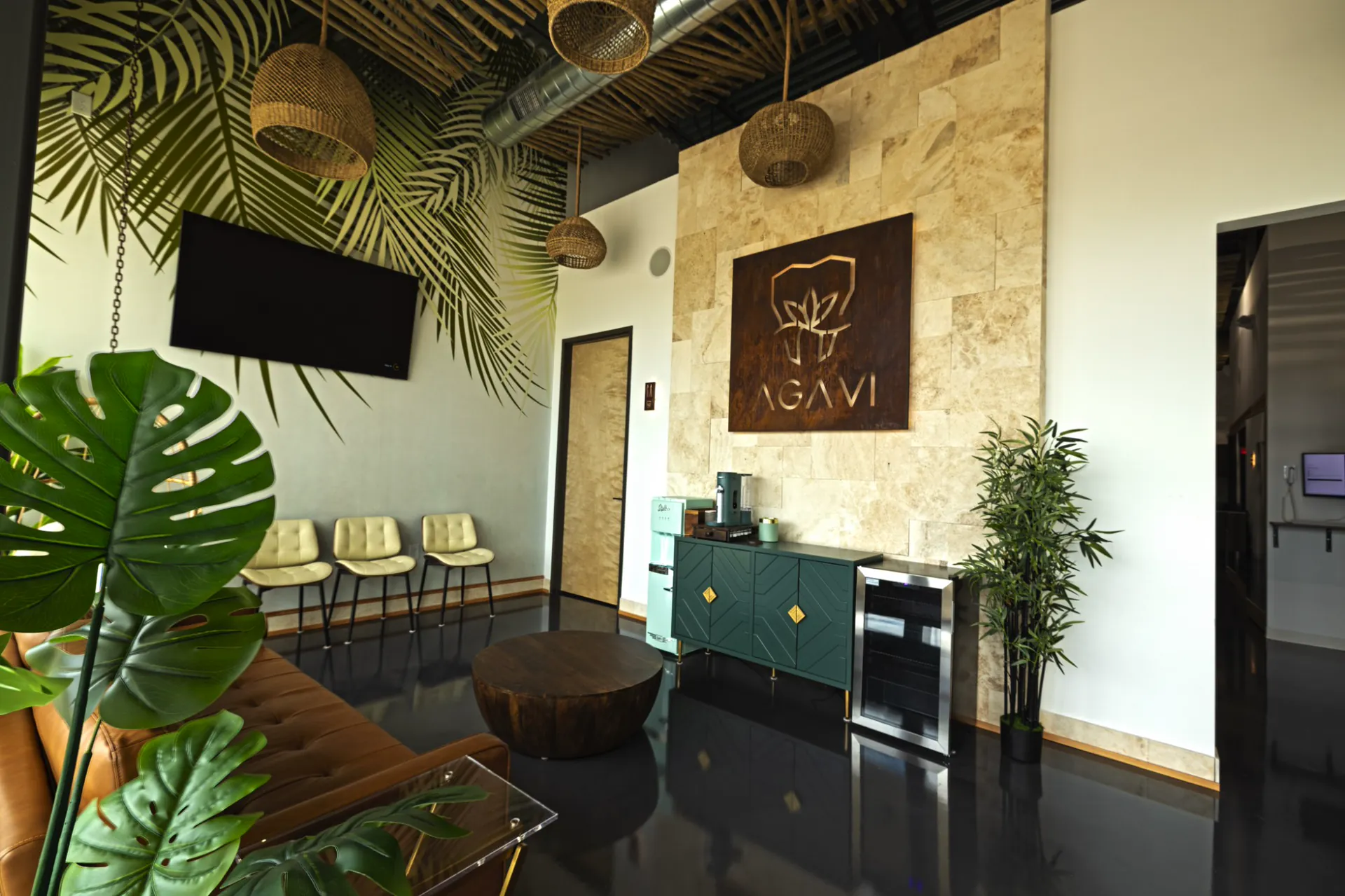 AGAVI Dental Studio lobby in Cypress, TX — travertine wall with the AGAVI sign, rattan pendants, palm mural